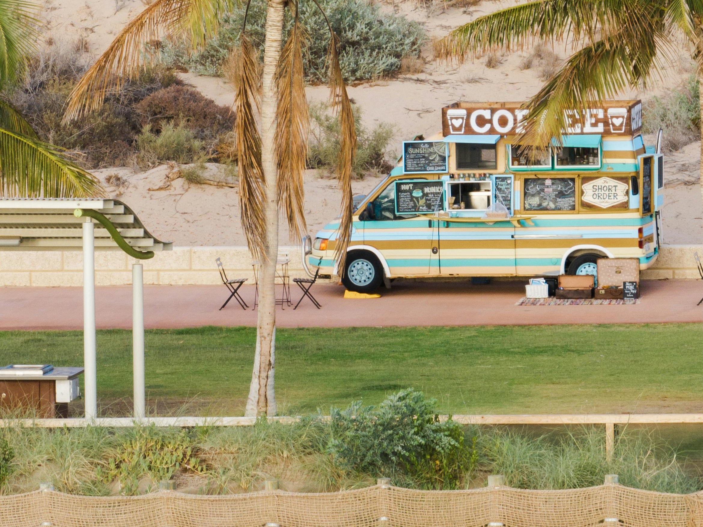 Food truck under palm trees in a scenic outdoor setting