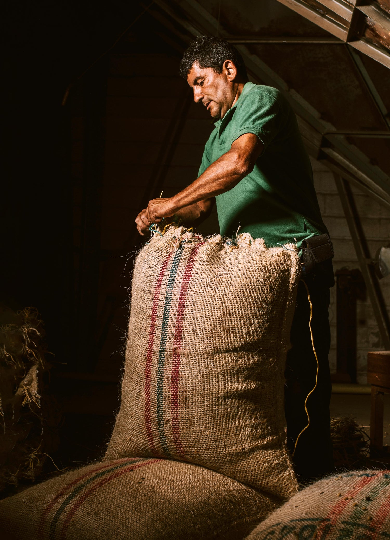 Man working with burlap sacks in a warehouse setting