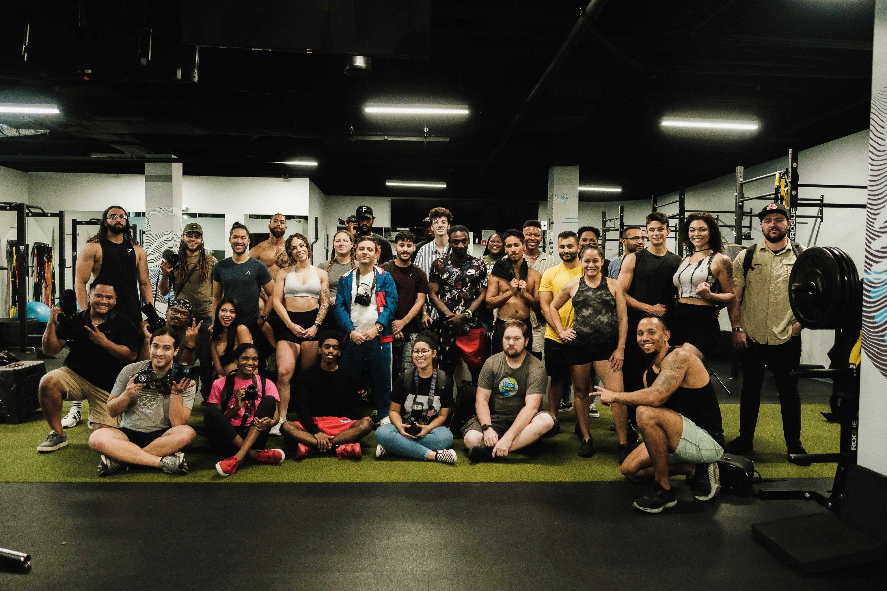 Group of people posing for a photo in a gym setting